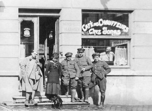 Des transformations ont été effectuées au niveau de la porte et des fenêtres. On y voit Alexina Fléron entourée d’un soldat et de chauffeurs. Alexina (normalienne à Verviers en 1918 ) semble regarder le petit chien assis à ses pieds.