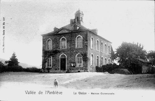 Carte postale  1900 : La place du village et la maison communale abritant l’école