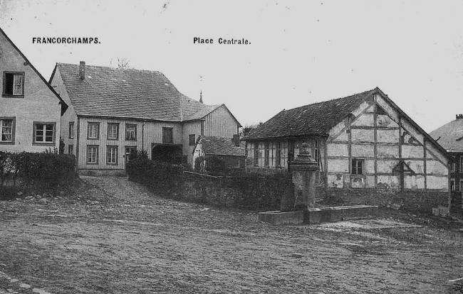 1900 : la fontaine de la place du Rond Chêne, une des 3 fontaines du village. Le bâtiment à colombages a abrité l’école et l’administration communale de 1847 à 1874