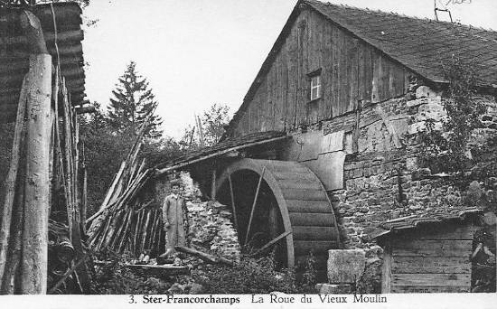 Carte postale : 1930 : le meunier pose à côté de la roue de l’ancien moulin banal